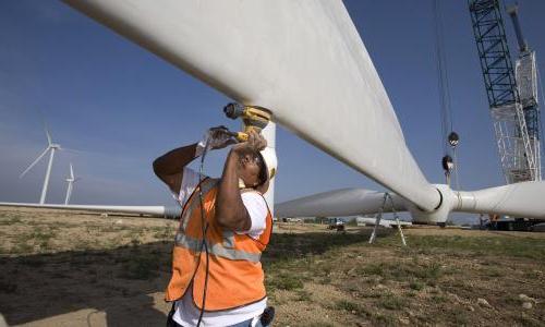 Worker helping to construct wind turbine blades.